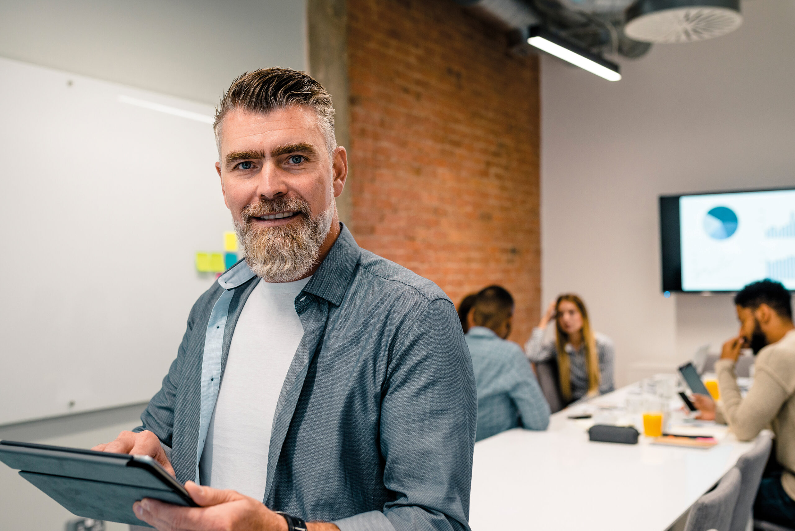 Mature businessman at a seminar working on computer. Meeting room. Brainstorming.